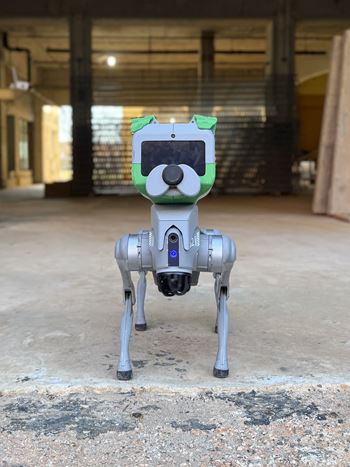 A robot dog is standing on a concrete floor.